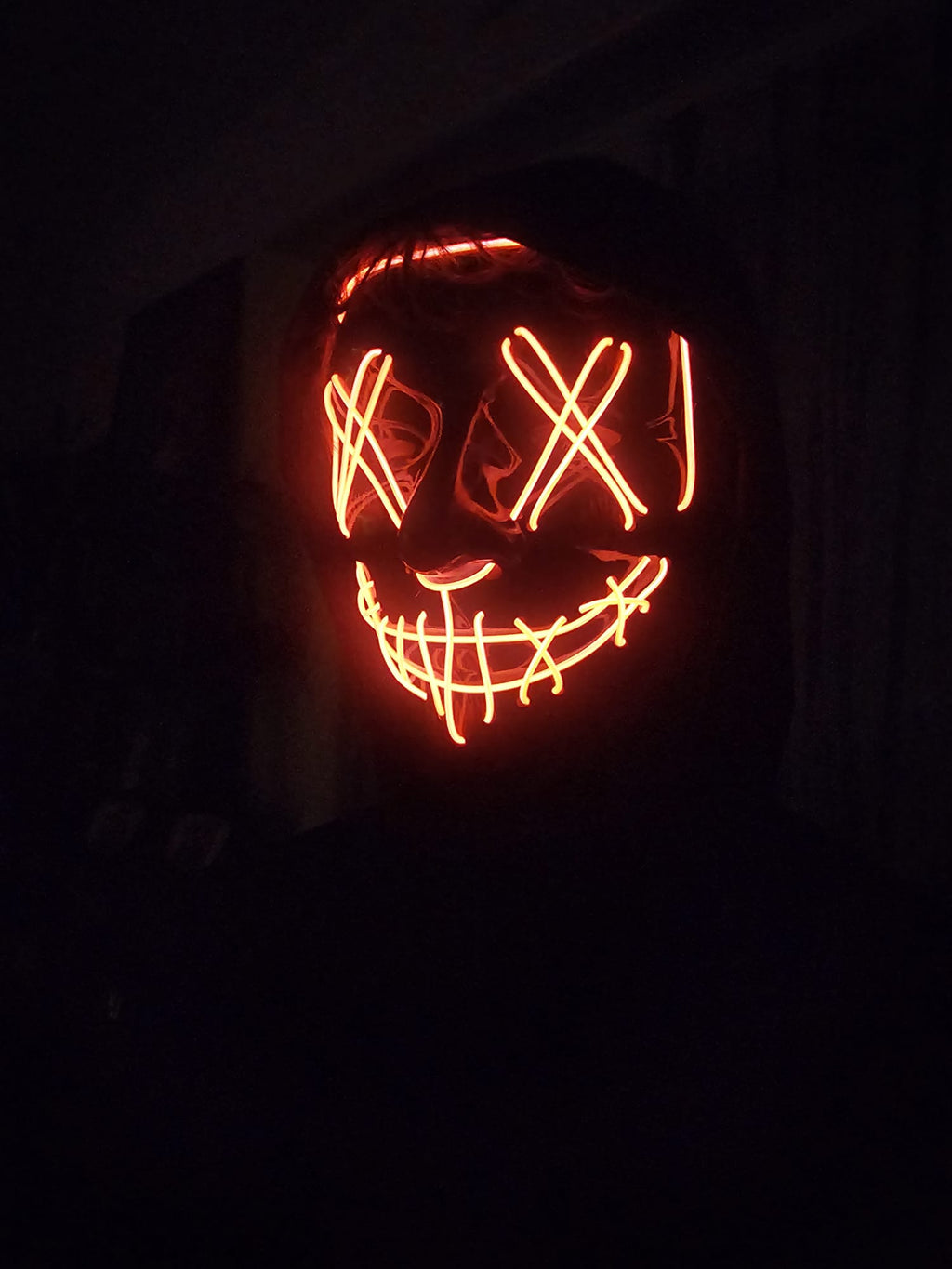 Masque LED Halloween orange porté dans l'obscurité, photo réelle